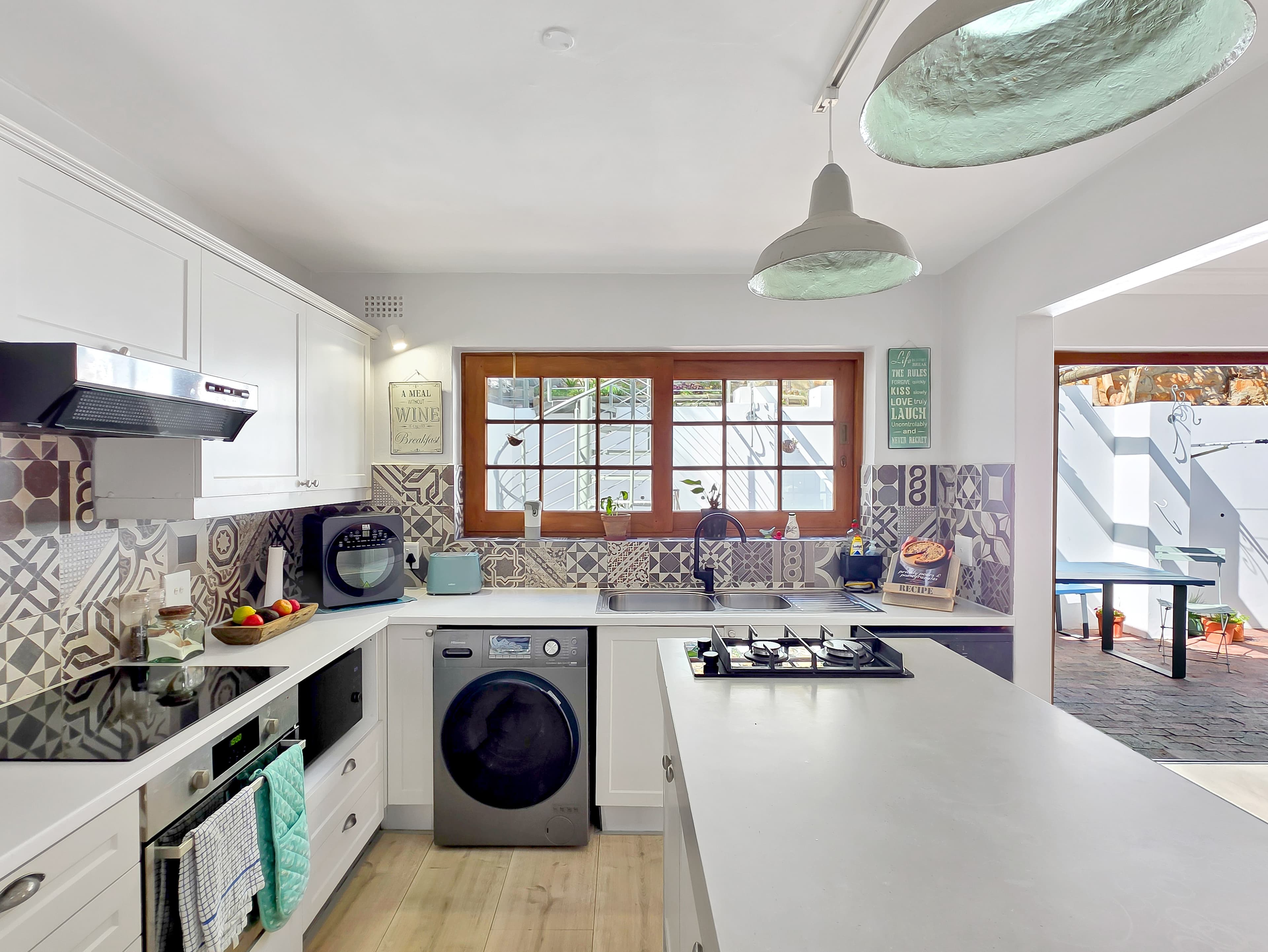 The kitchen is fully equipped with appliances, including a coffee machine and dishwasher.