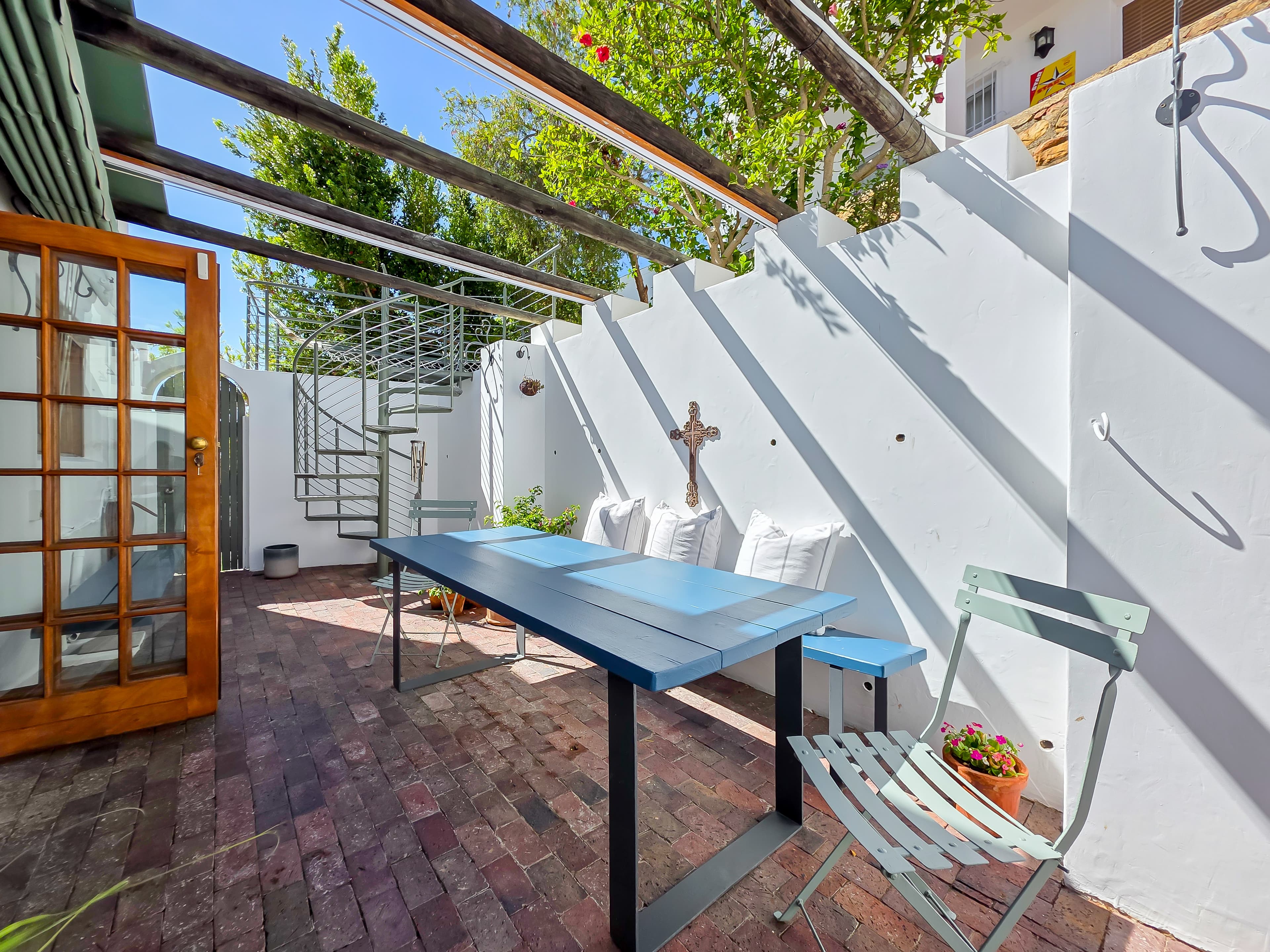 The outdoor eating area with spiral staircase up to the hammock and terraced garden. 