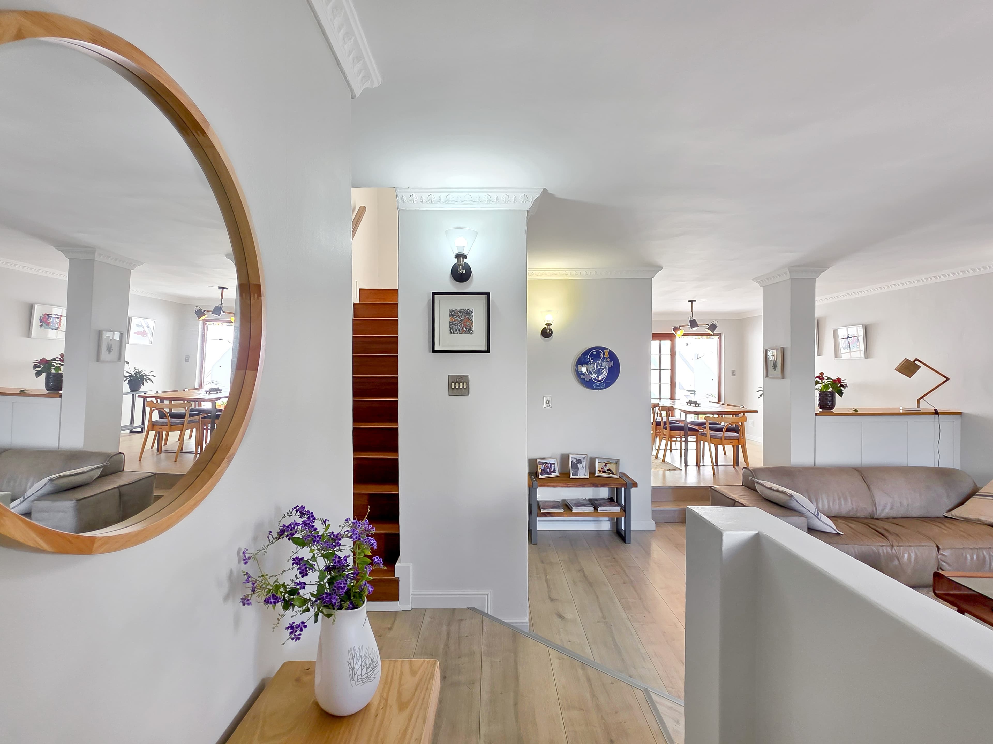 The living room, kitchen and outdoor area beyond, seen from the front door entrance area.